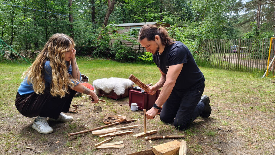 Deelnemers leren vuur maken met tondel en hout